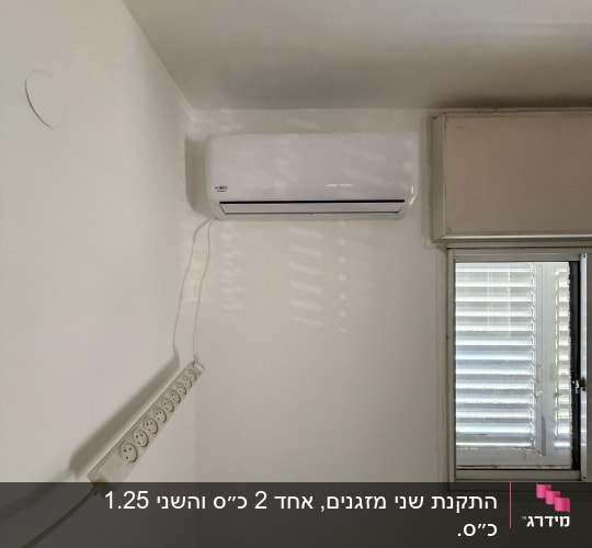 מזגן מותקן על קיר ליד חלון